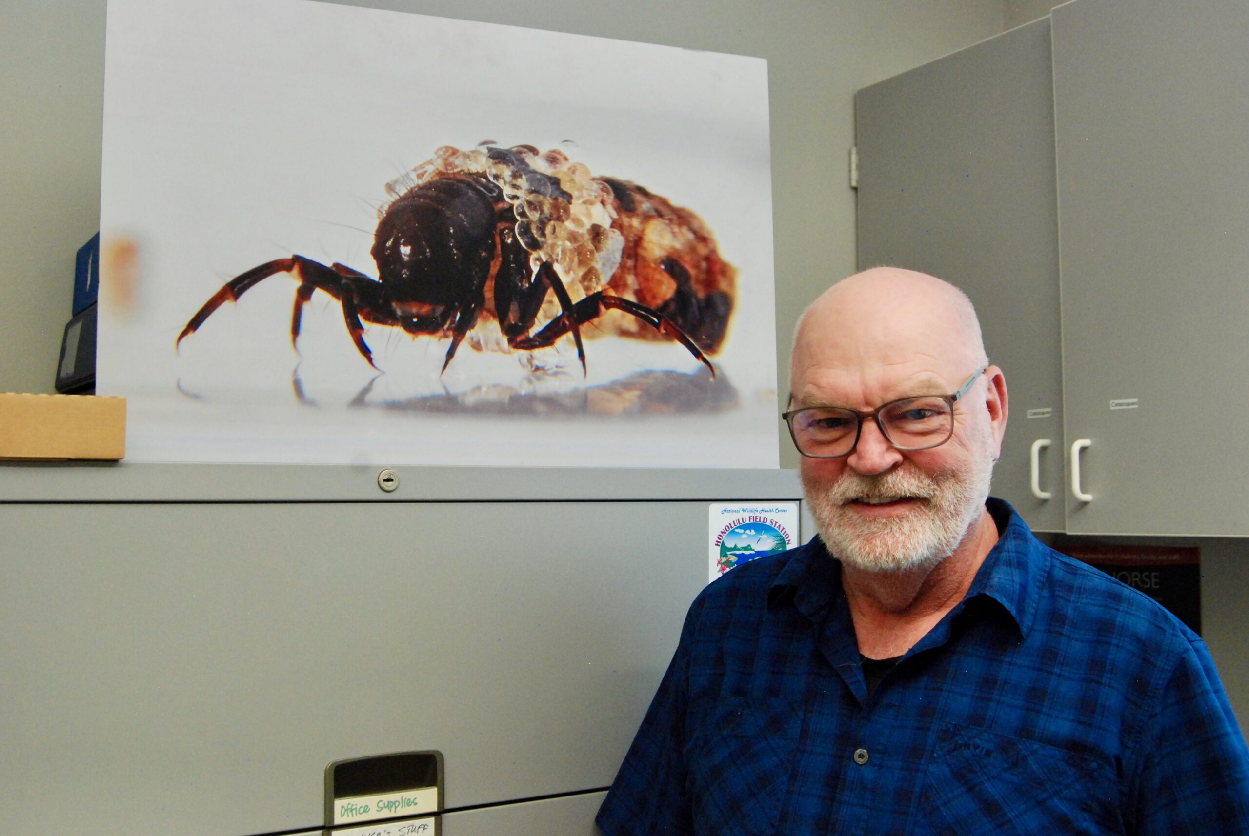 Russell Stewart in his lab in the U&rsquo;s Biomedical Polymers Research Building beside a photo of a caddisfly larva. Credit: Brian Maffly.